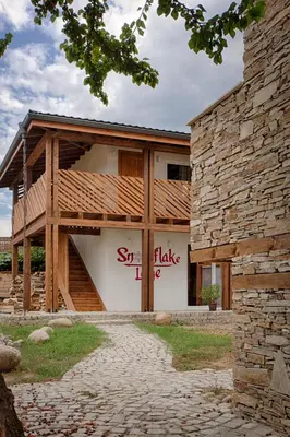 a building with a sign that reads synergy take at Къщи за гости Сноуфлейк Snowflake Chalet and Snowflake Lodge in Bansko