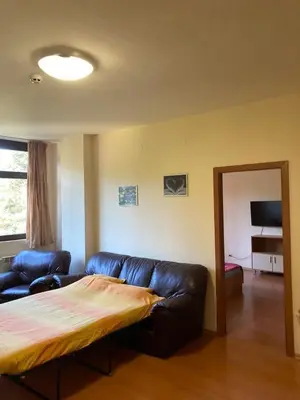 a living room with a leather couch and a mirror at Flora Apartment 613 in Borovets