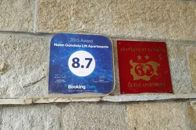 a sign on the side of a brick wall at Large Gondola Apartment - Center, Neon in Bansko