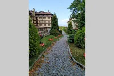 a cobblestone path in front of a building at Large Gondola Apartment - Center, Neon in Bansko