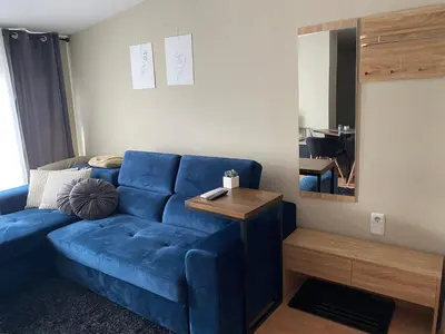 a blue couch in a living room with a mirror at Studio Deluxe Mian in Beli Iskar