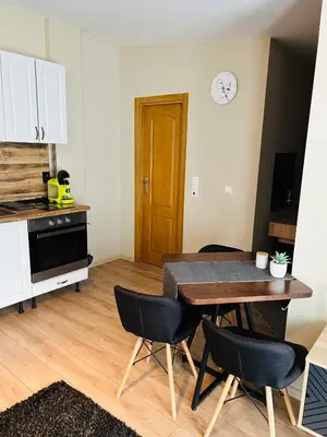 a kitchen with a table and chairs and a clock on the wall at Studio Deluxe Mian in Beli Iskar