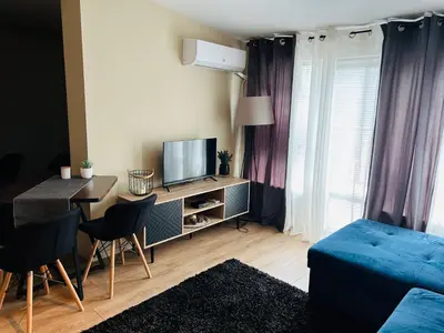 a living room with a blue couch and a television at Studio Deluxe Mian in Beli Iskar