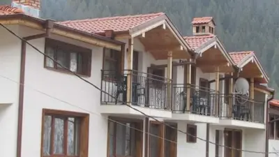 a large building with balconies on the side of it at Къща за гости Камината in Trigrad