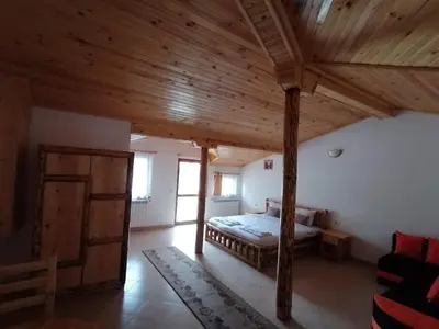 a bedroom with a bed and a wooden ceiling at Къща за гости Камината in Trigrad