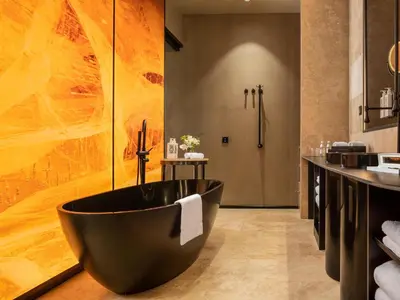 a bathroom with a large black tub in the middle at The Emporium Hotel Plovdiv - MGallery Collection in Plovdiv