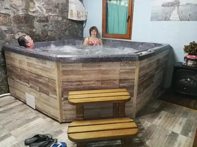 a woman in a jacuzzi tub with a person in it at Hotel Rai in Koprivshtitsa