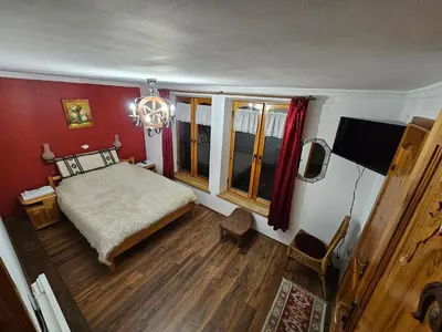 a bedroom with a bed and a large window at Hotel Rai in Koprivshtitsa