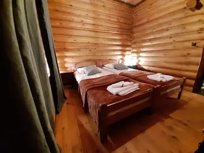 a room with two beds in a log cabin at къщи за гости Под звездите in Pamporovo