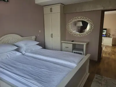 a bedroom with a large bed with a mirror at Студио Лидия in Velingrad