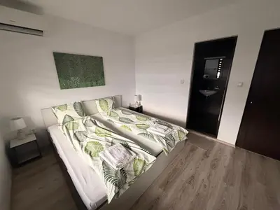a bedroom with a bed with green and white pillows at Марковската къща in Oreshak