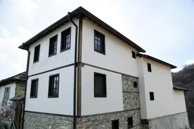 an old building with black windows at Galabova Guesthouse in Delchevo