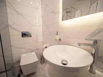 a white bathroom with a toilet and a sink at The Moon Boutique Hotel in Sofia