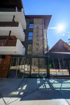 a building with a sign on the side of it at 103 Alpine Hotel in Panichishte