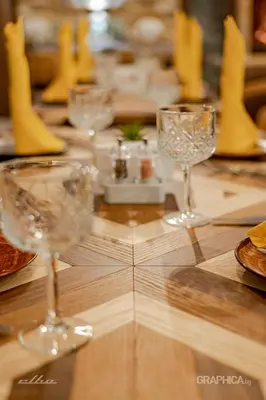 a table with wine glasses on a wooden table at 103 Alpine Hotel in Panichishte