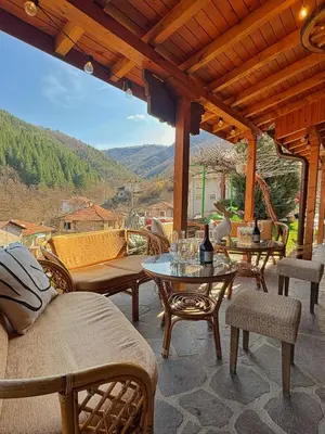 a patio with a table and chairs and a view at Къща за гости Хаджиевата къща in Smolyan