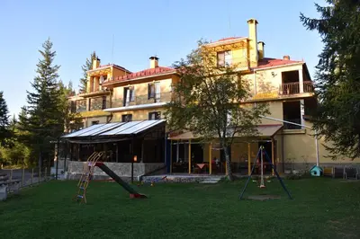 a house with a playground in front of a building at Хотел Сима in Beklemeto