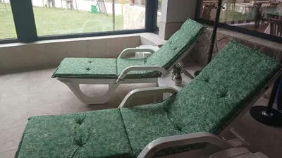 two green chairs and a table in a room at Хотел Сима in Beklemeto