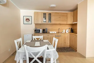 a kitchen with a table and chairs in a room at Апартамент В4 in Velingrad