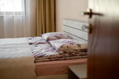 a bed with pillows on it in a bedroom at Апартамент В4 in Velingrad