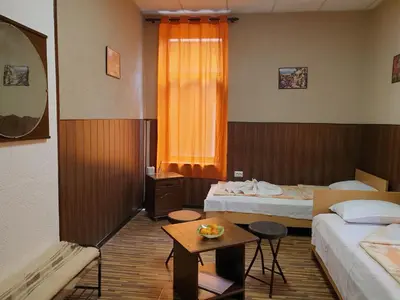 a hotel room with two beds and a table at KM!Sofia - Стаи за гости in Sofia