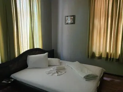 a bed with white sheets and pillows in a bedroom at KM!Sofia - Стаи за гости in Sofia
