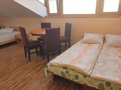 a room with two beds and a table and chairs at KM!Sofia - Стаи за гости in Sofia