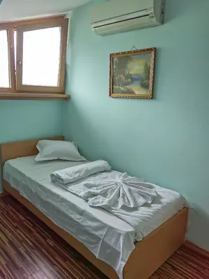 a bed in a room with a picture on the wall at KM!Sofia - Стаи за гости in Sofia