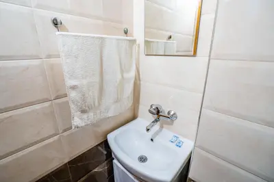 a bathroom with a sink and a toilet and a mirror at Toni's Guest House in Melnik
