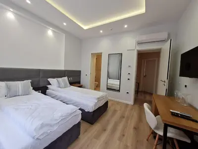 a bedroom with two beds and a table and a desk at Hotel House K21 in Sofia