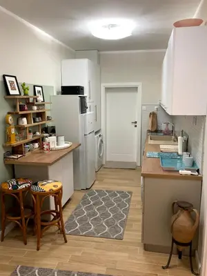 a kitchen with a refrigerator and a table and chairs at Diva Garden Apartment in Plovdiv