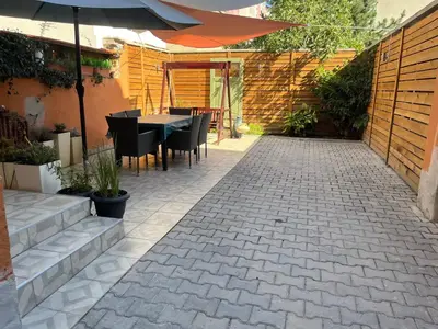 a patio with a table and chairs and an umbrella at Diva Garden Apartment in Plovdiv