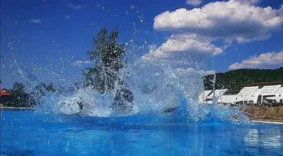 a splash of water in the middle of a swimming pool at Къща за гости Volpe - Volpe Guesthouse in Oreshak