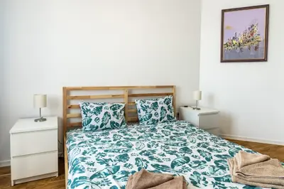 a bedroom with a bed with blue and white sheets at Bendida Central in Velingrad