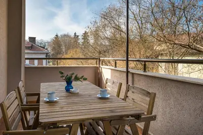a wooden table and chairs on a balcony with a window at Bendida Central in Velingrad