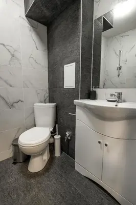 a bathroom with a white toilet and a sink at Bendida Central in Velingrad