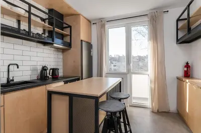 a kitchen with a counter with two stools and a window at Industrial 2-BDR Flat by the National Stadium by Flat Mаnager in Sofia