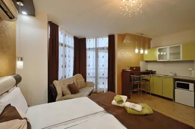 a hotel room with a bed and a kitchen and a room at Fantasy Apartaments and studios Avenue комплекс Фантазия Хисаря in Hisarya