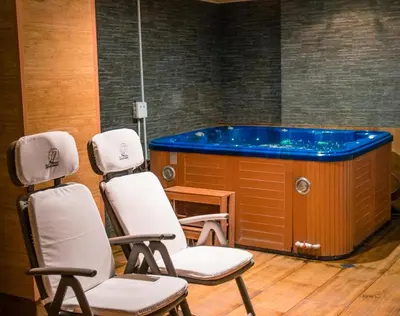 two chairs and a tub in a room at Fantasy Apartaments and studios Avenue комплекс Фантазия Хисаря in Hisarya