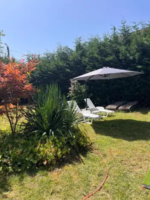 an umbrella and chairs sitting in a yard at Guest House 