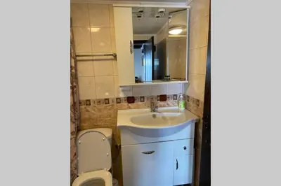 a bathroom with a sink and a toilet and a mirror at Guest House 