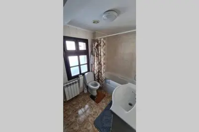 a bathroom with a toilet and a sink and a window at Guest House 