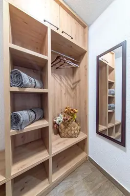 a walk in closet with wooden shelves and a mirror at Българче Хотел - Ресторант in Smolyan