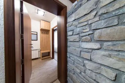 a stone wall in the hallway of a house at Българче Хотел - Ресторант in Smolyan