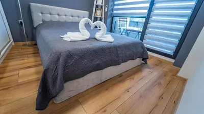 two swans sitting on a bed in a bedroom at Niko's Cozy Apartment in Plovdiv