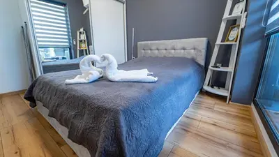 two swans sitting on a bed in a bedroom at Niko's Cozy Apartment in Plovdiv
