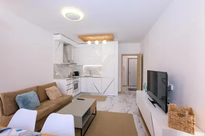 a living room with a couch and a tv at Лукс Апартамент Радост 2 in Sandanski