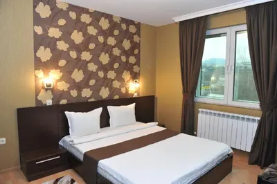 a bedroom with a bed with a flowery wall at Eros Motel in Sandanski