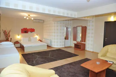 a hotel room with a bed and a living room at Eros Motel in Sandanski