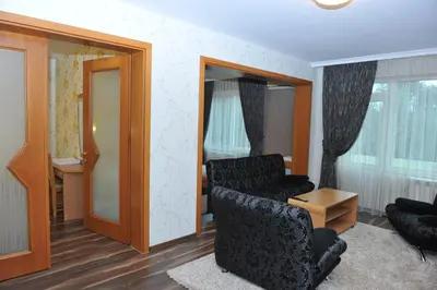a living room with a black chair and a mirror at Eros Motel in Sandanski